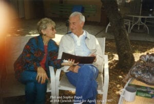 A man and woman sitting on the ground.