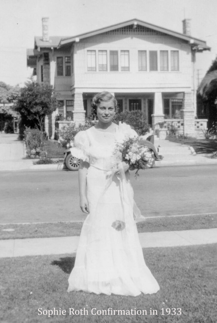 A woman in a white dress standing on the side of a road.