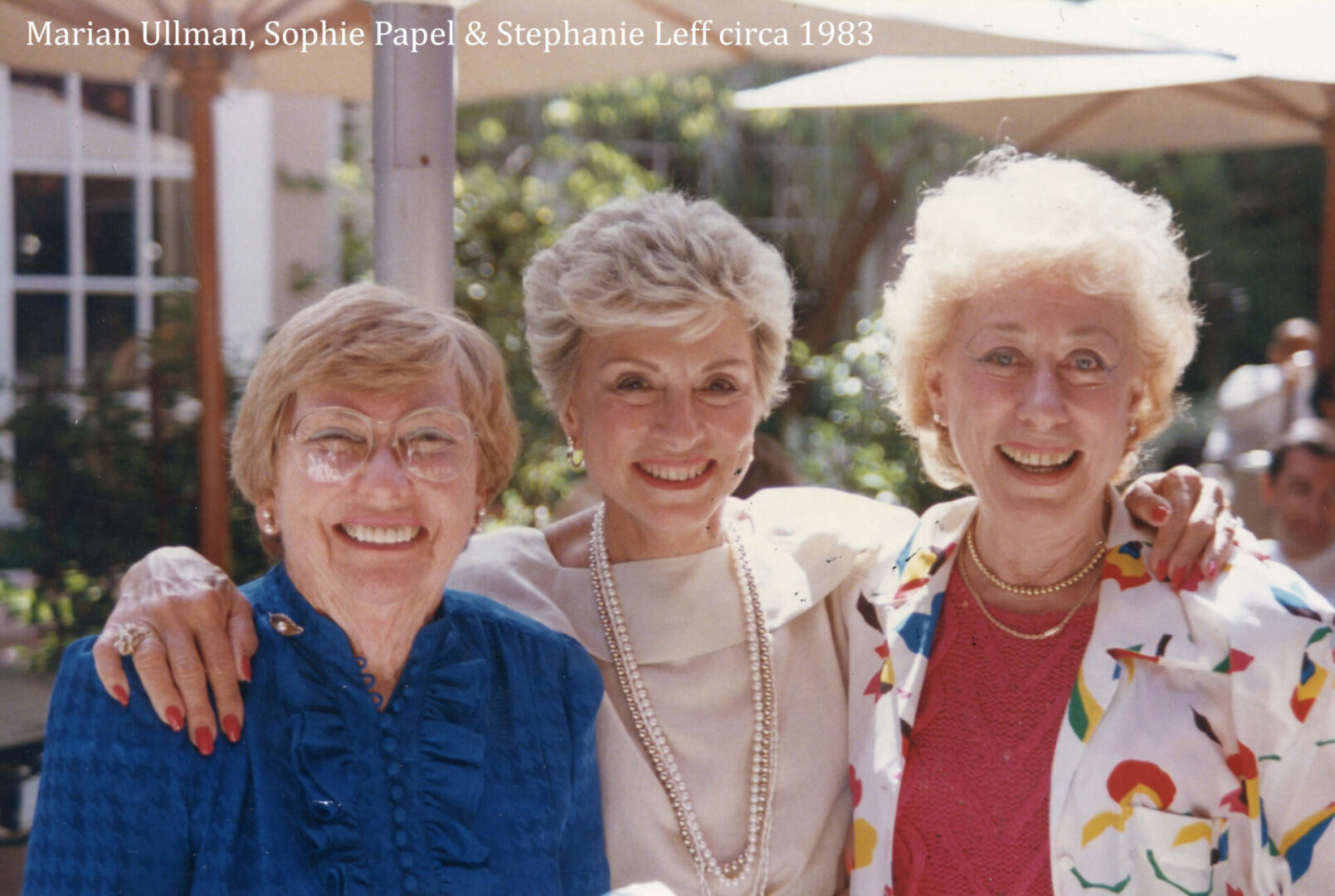 Three women smiling for a picture together.