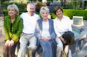 A group of people sitting on top of a bench.