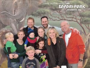 A group of people posing for a picture in front of an elephant.