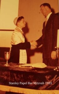 A young boy shaking hands with an older man.