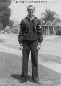 A man in a sailor 's uniform standing on the street.