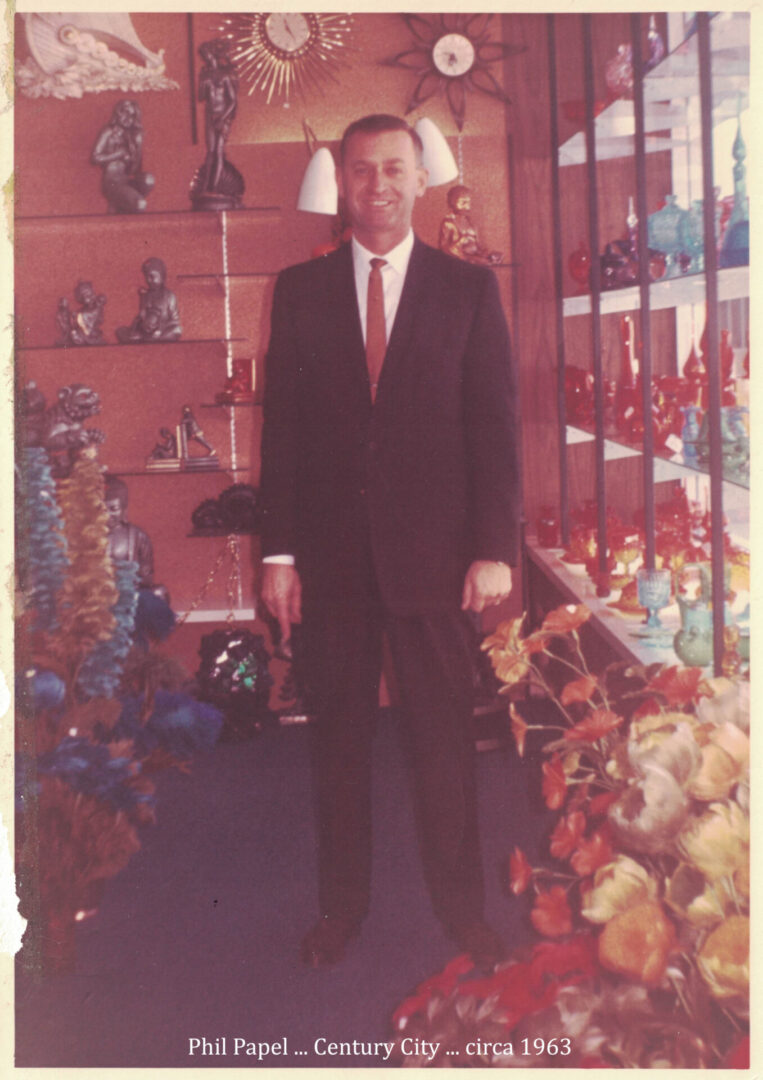 A man in suit and tie standing next to some toys.